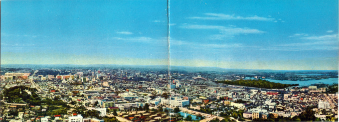 Panoramic view of Tokyo looking east-northeast from Tokyo Tower, c. 1960. The Imperial Palace grounds are at left; the wooded Hama Detached Palace is at right, astride Tokyo Bay.