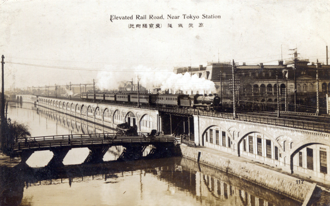 A C51 locomotive pulling Tokaido Main Line carriages past the Imperial Hotel, at Yamashitacho-bashi, on arrival into Tokyo, c. 1920.